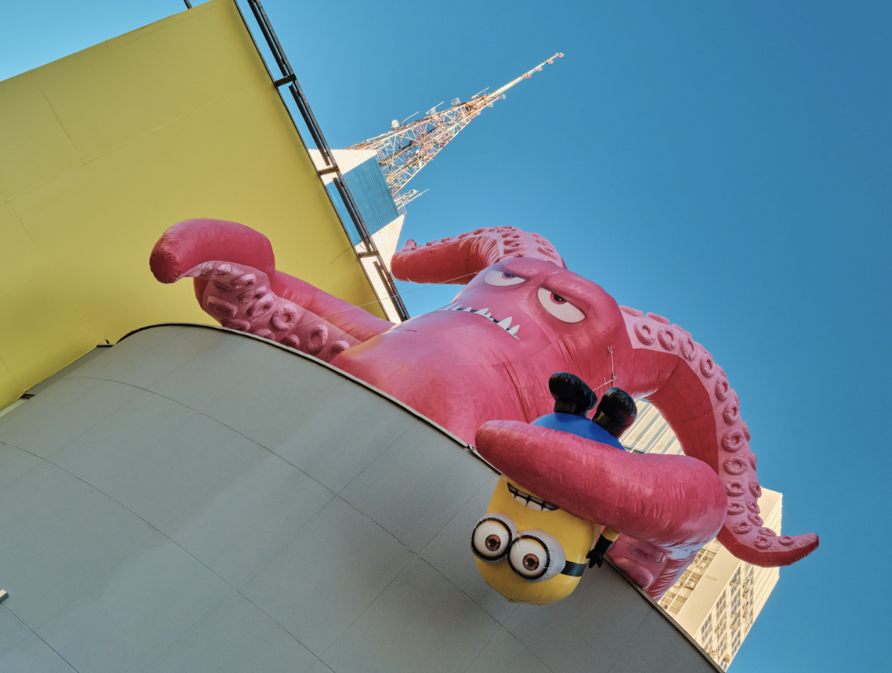 Polvo inflável gigante e Minion no topo da fachada, visto de baixo